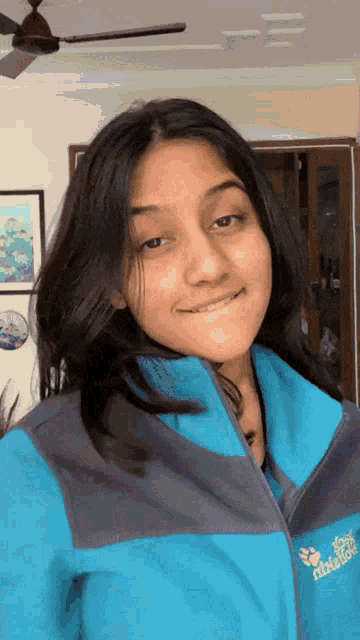 a woman wearing a blue jacket that says jack wolfskin on it