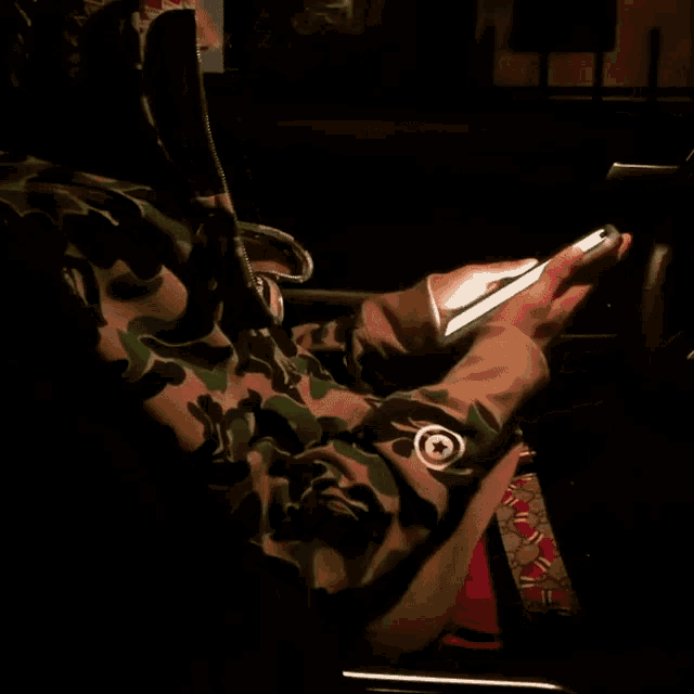 a person wearing a camouflage jacket with shark teeth
