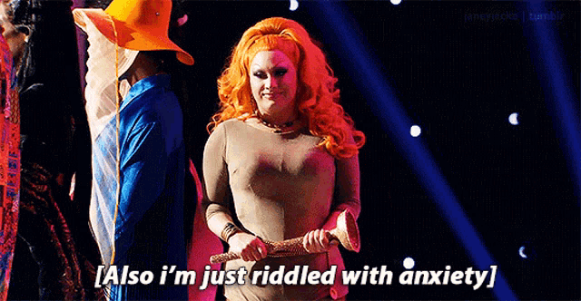 a drag queen is holding a stick and saying `` also i 'm just ridded with anxiety '' .