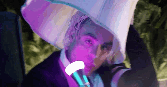 a man is wearing a white hat and holding a purple light