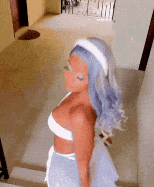 a woman with blue hair and a white headband is walking down stairs