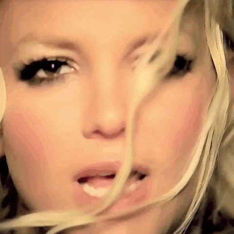 a close up of a woman 's face with long blonde hair blowing in the wind
