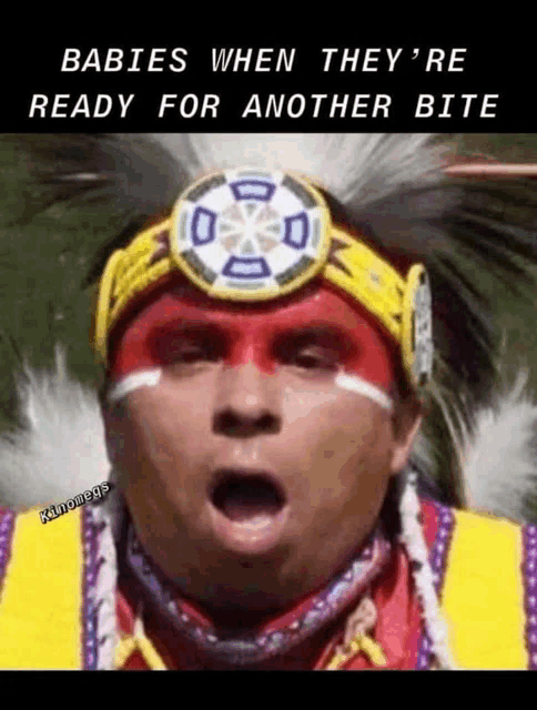 a man wearing a native american headdress is ready for another bite .