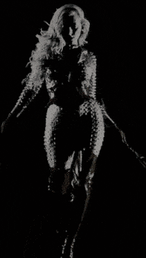 a woman with white wings is standing in front of a wall