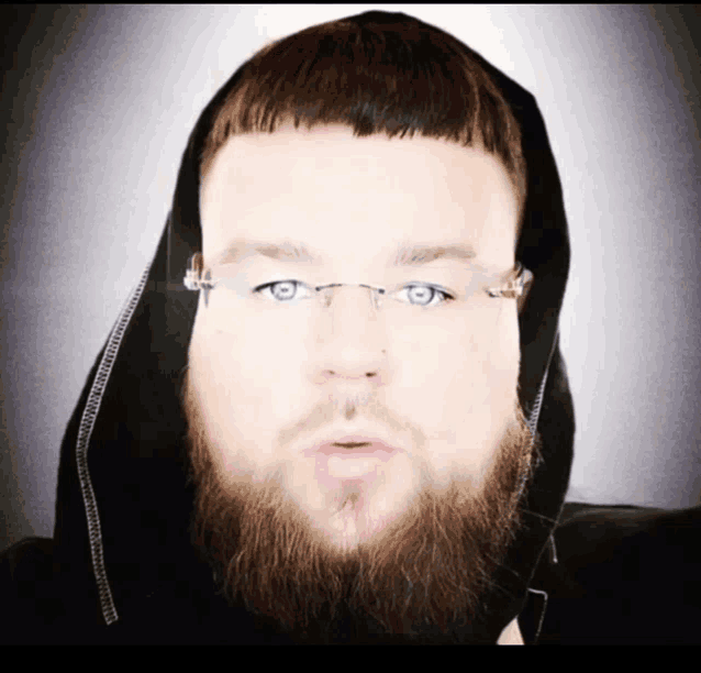 a man with a beard wearing glasses and a hood