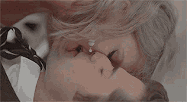 a woman is kissing a man in a tuxedo
