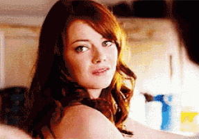 a woman with red hair is looking at the camera