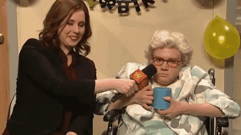 an elderly woman in a wheelchair is being interviewed by a woman holding a microphone
