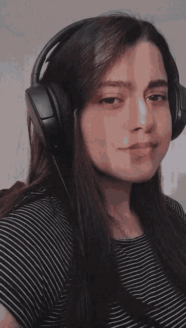 a woman wearing headphones is looking at the camera