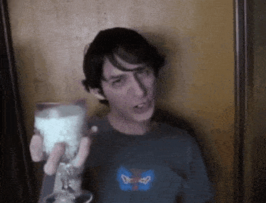 a man is holding a glass of milk in his hand .