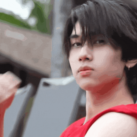 a close up of a person 's face with a red tank top on