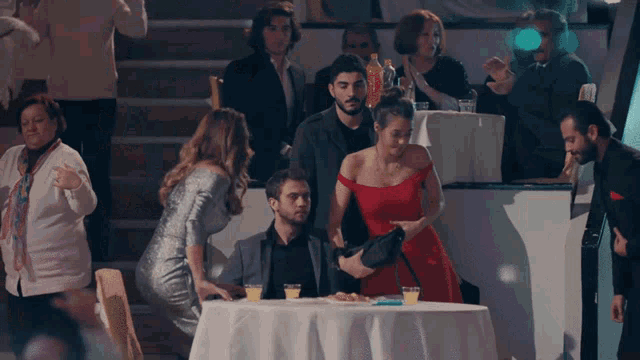 a woman in a red dress is standing next to a man