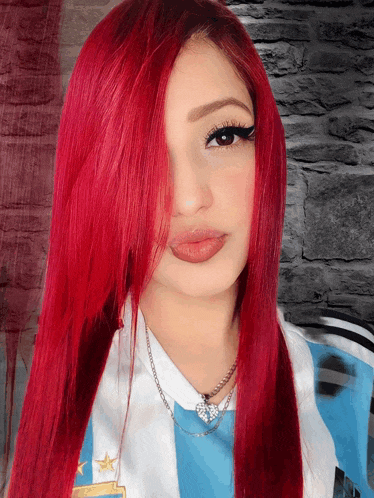 a woman with red hair is wearing a blue and white striped shirt