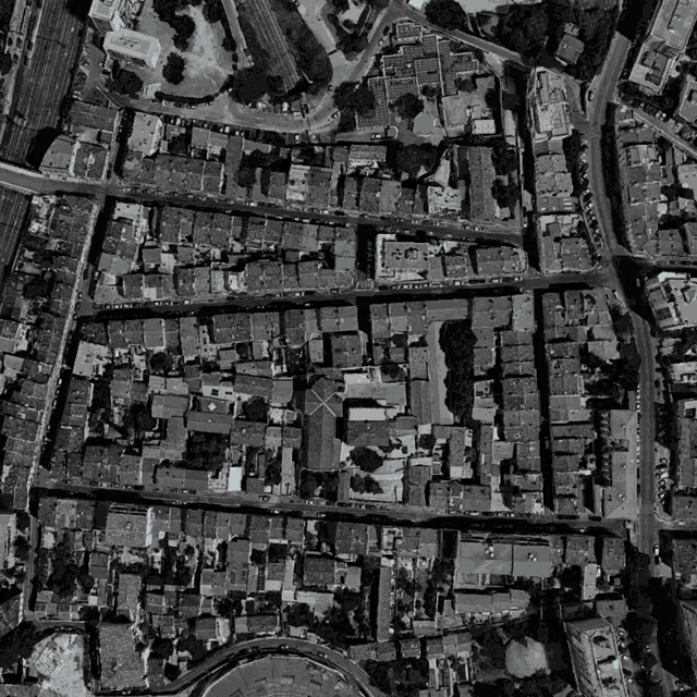 a black and white aerial view of a residential area with a church in the middle
