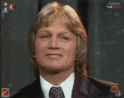a man in a suit and tie is looking at the camera with a clock in the background that says clock the big