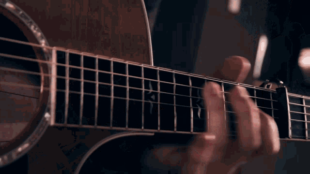three people playing guitars and singing into microphones