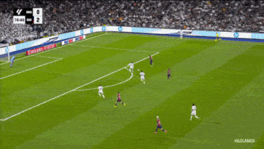 a soccer game is being played on a field with an emirates advertisement on the sidelines