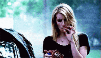 a woman is smoking a cigarette while holding a bag of candy .