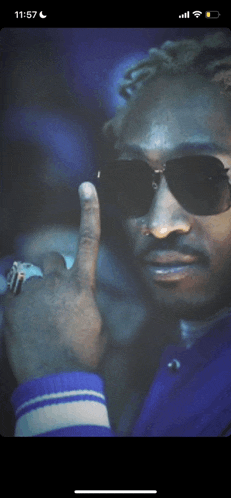 a man wearing sunglasses and a ring is shown on a phone screen