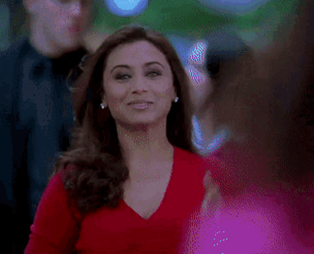 a woman wearing a red shirt and a diamond ring on her finger