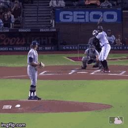 a baseball game is being played with a geico banner in the background