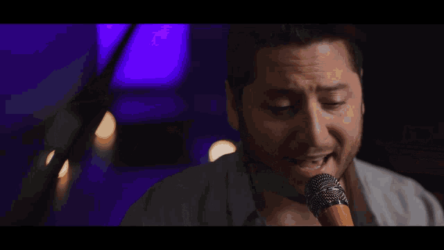 a man singing into a microphone with a beard