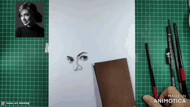 a drawing of a woman 's face is being made on a cutting board