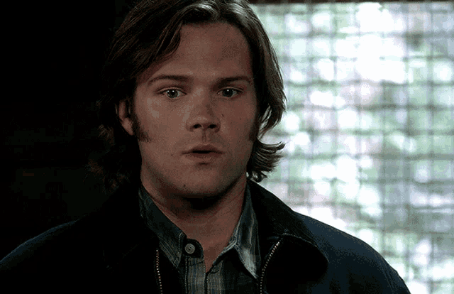 a man with a surprised look on his face is wearing a jacket