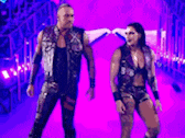 a man and a woman are walking in a purple tunnel .