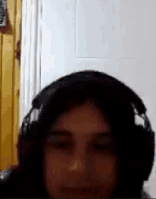 a woman wearing headphones is looking at the camera in a video call .