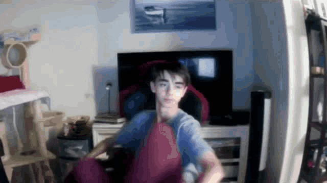 a young boy is sitting in front of a television in a room