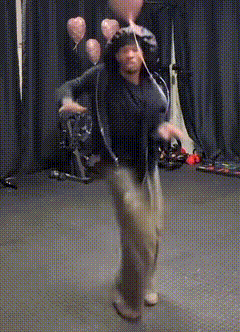 a man is dancing with balloons in the background