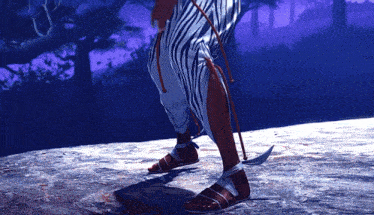 a person standing on a rock wearing a striped skirt and sandals