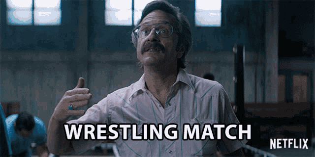 a man with a mustache and glasses says wrestling match