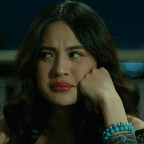 a woman with a turquoise bracelet on her wrist looks sad