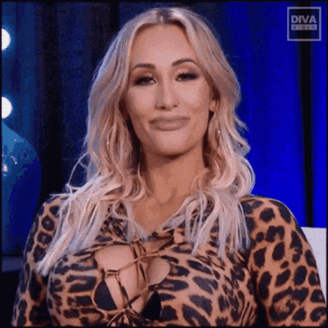 a woman in a leopard print dress is smiling and looking at the camera