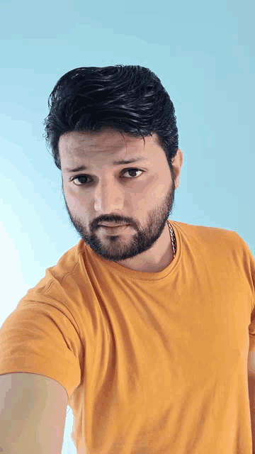 a man with a beard is wearing an orange shirt