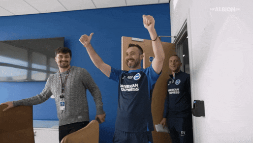 a man wearing a blue american express jersey stands in a room