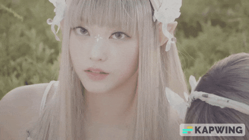 a girl with a white flower in her eye and the word kapwing behind her