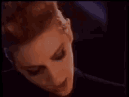 a close up of a woman 's face in a dark room .