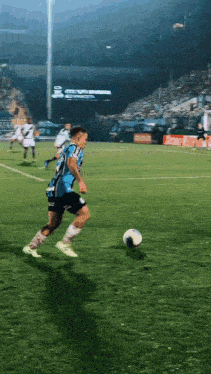 a soccer player wearing a blue jersey that says ' coca-cola ' on it