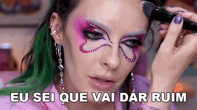 a woman applying makeup with the words eu sei que vai dar ruim written below her