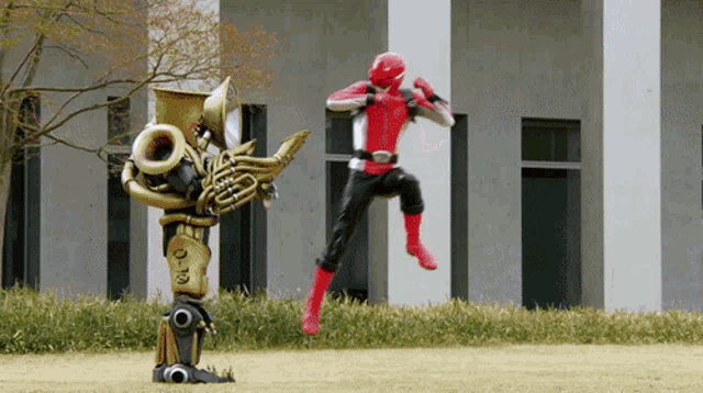 a robot playing a trumpet stands next to a man in a red costume