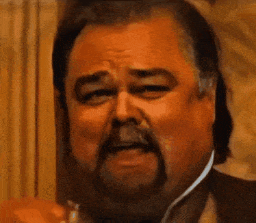 a man with a beard and mustache is making a face .