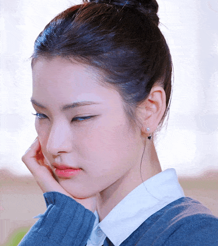 a close up of a woman 's face with a bun
