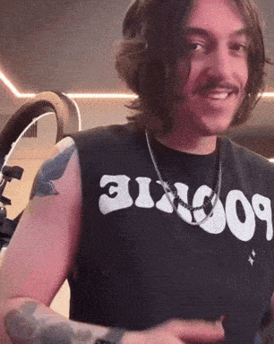 a man with a tattoo on his arm wears a black shirt that says ' boogie ' on it