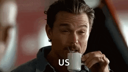 a man with a mustache is drinking a cup of coffee with a spoon in his mouth .