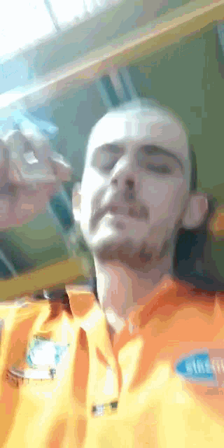 a man wearing a yellow shirt with a ford logo on it
