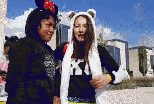 a girl wearing a hoodie that says ' bts ' on it stands next to another girl