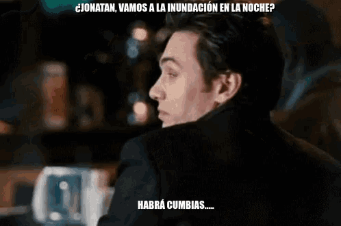 a man sitting at a bar with a caption in spanish that says habra cumbias